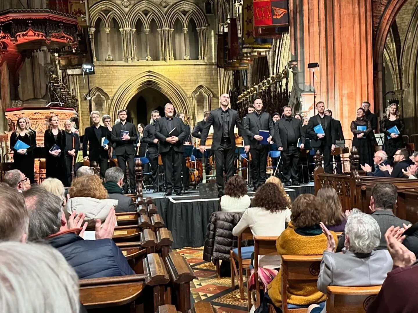 Soloists, choir and orchestra take a bow in a Gothic church after a concert