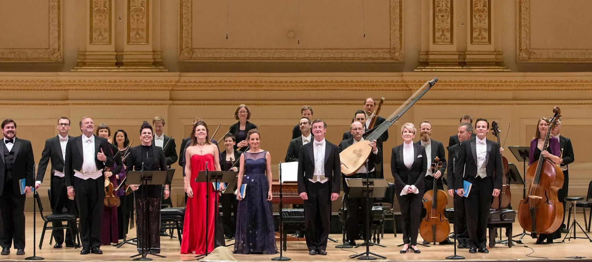 Soloists and a period-instrument orchestra bow on a gilded concert-hall stage