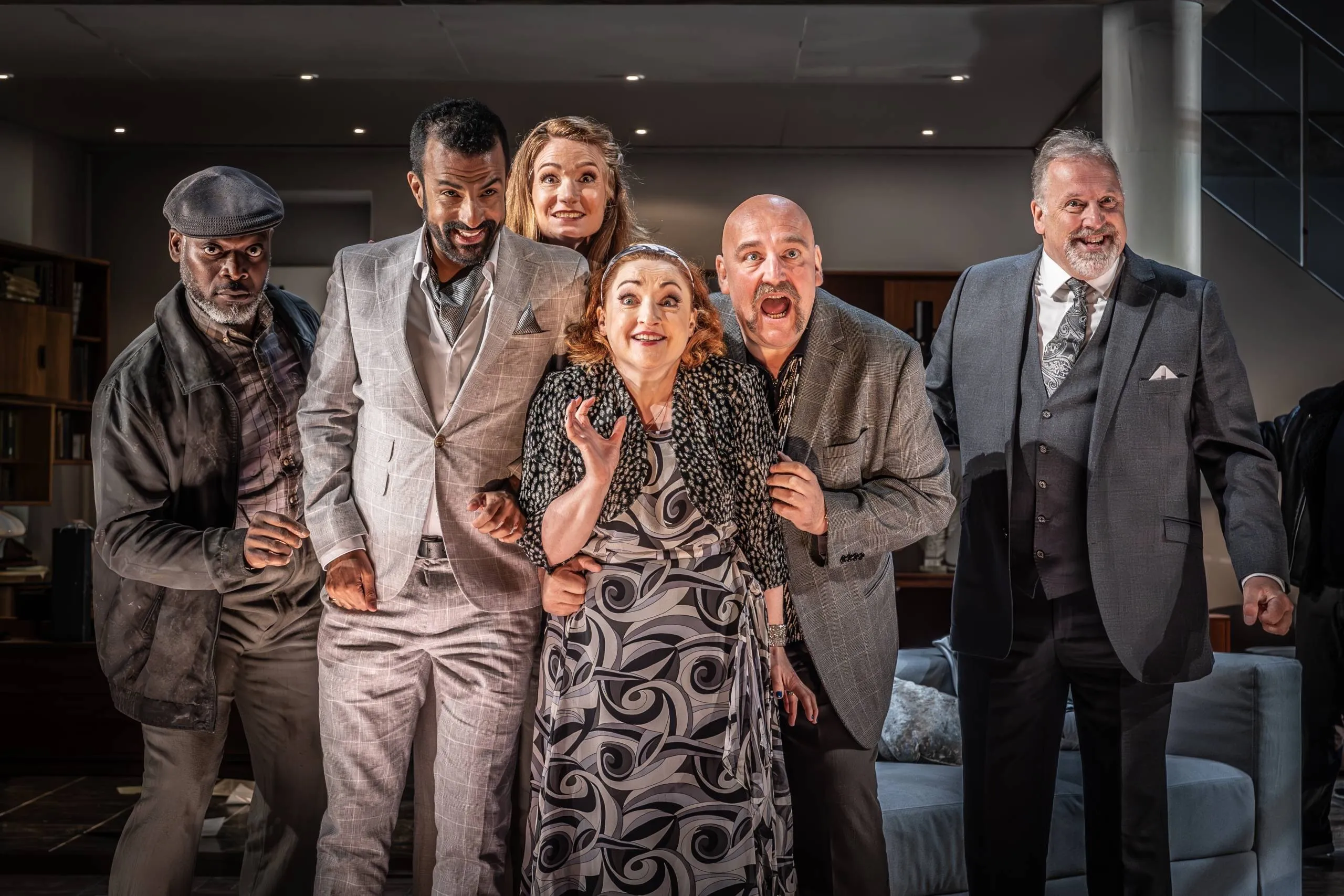 The cast of a Grange Park Opera production gathered in a modern apartment set