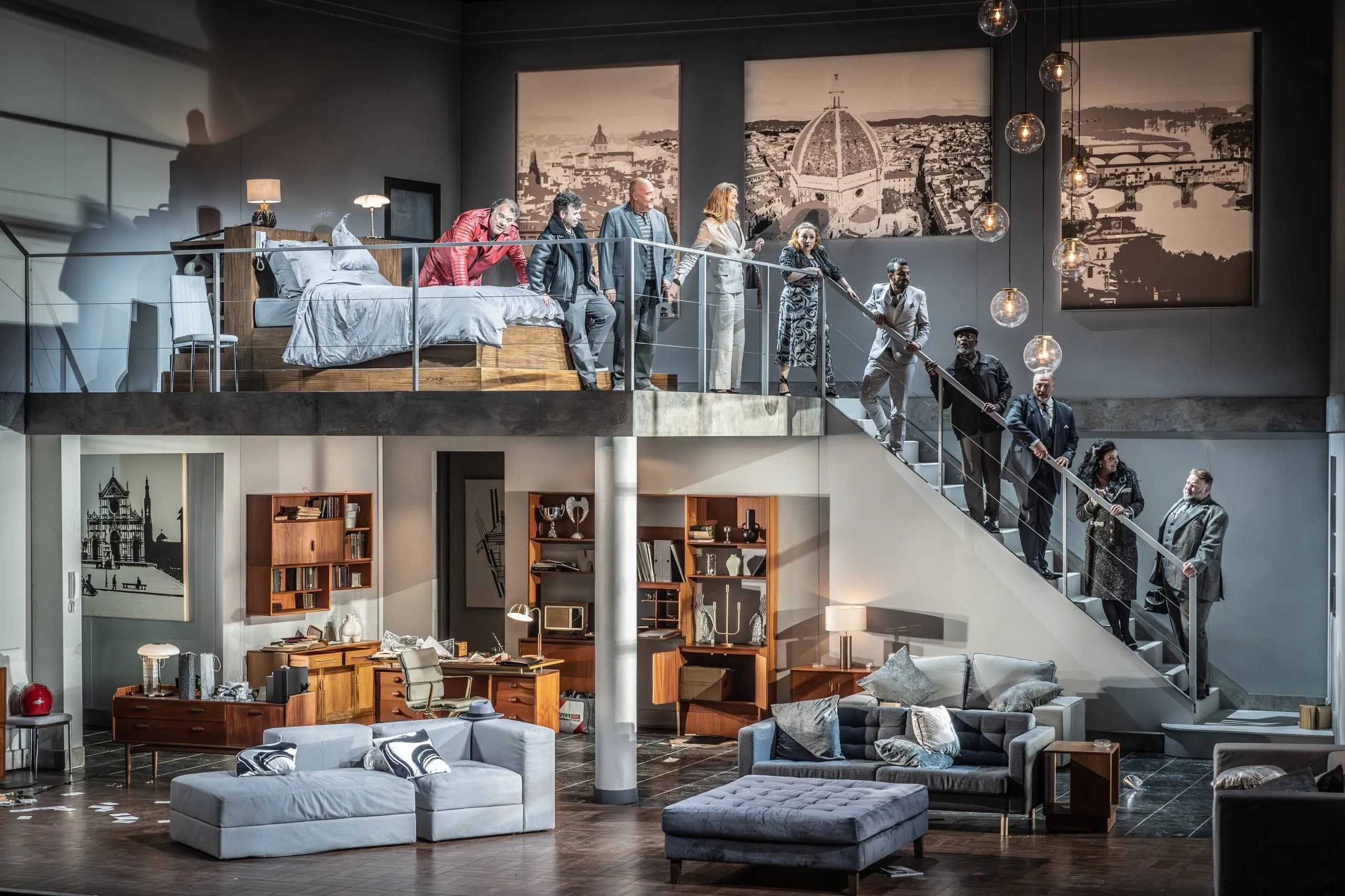 A two-storey apartment set with the full cast on stage at Grange Park Opera