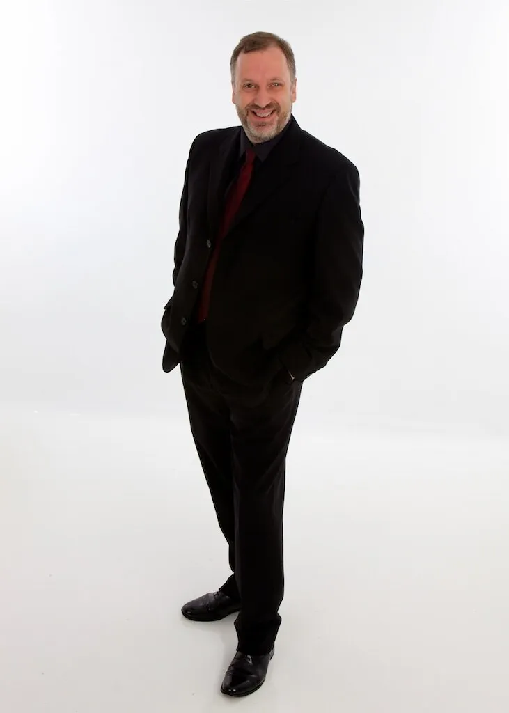 Full-length studio portrait of Matthew Brook in black against a white background